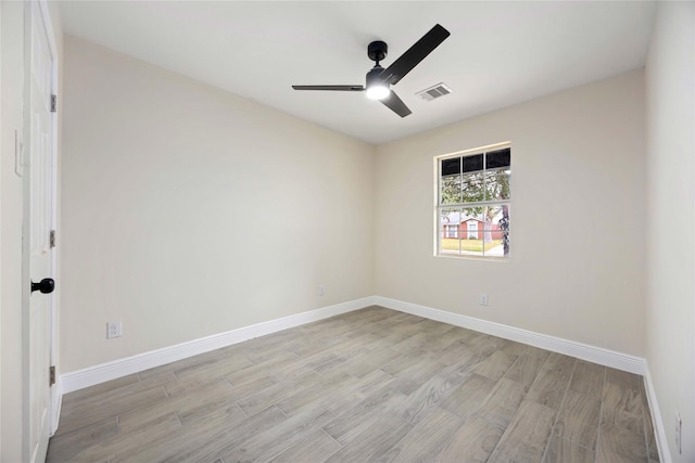 spare room featuring visible vents, baseboards, light wood-type flooring, and a ceiling fan