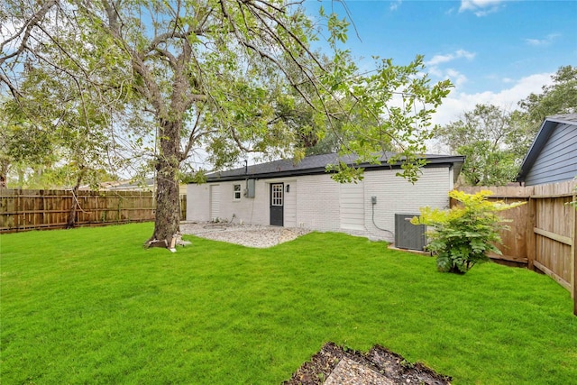 back of house with cooling unit, a yard, and a fenced backyard