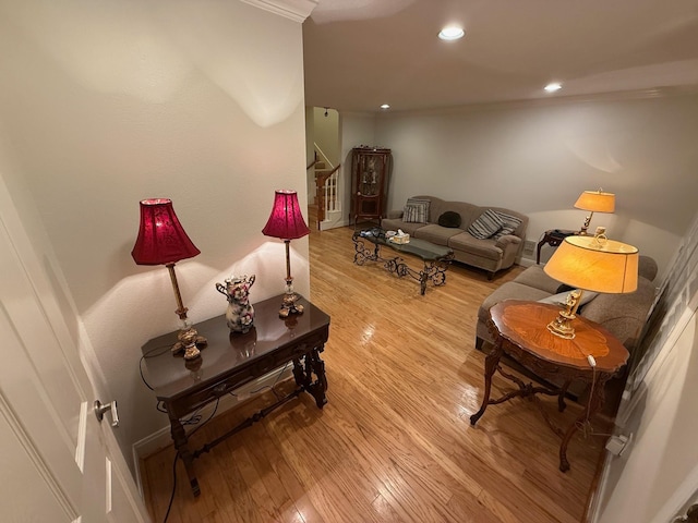 living area with recessed lighting, light wood-type flooring, baseboards, and stairs