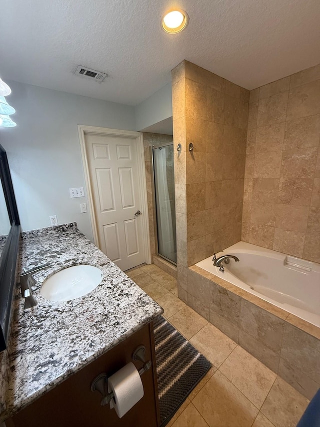 bathroom featuring visible vents, a stall shower, a textured ceiling, a garden tub, and tile patterned floors