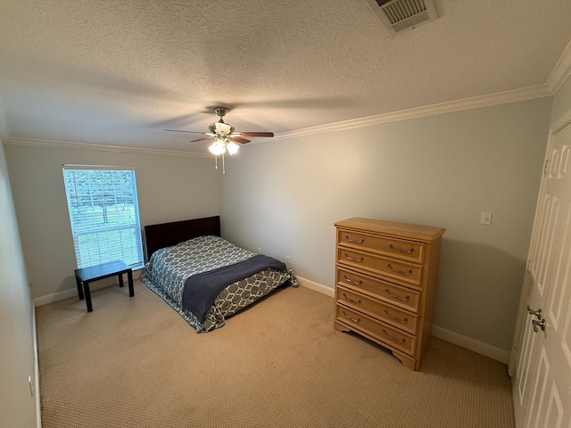 bedroom with a textured ceiling, light colored carpet, visible vents, and ornamental molding