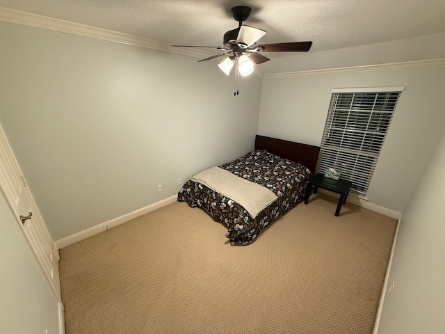 carpeted bedroom with ceiling fan, baseboards, a textured ceiling, and ornamental molding