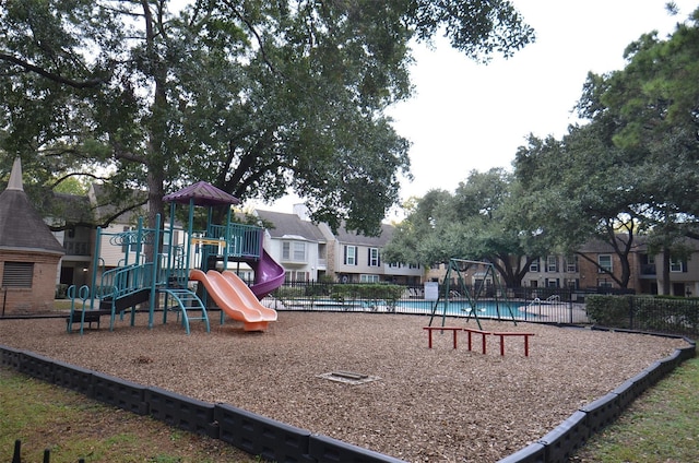 community playground with a residential view and fence