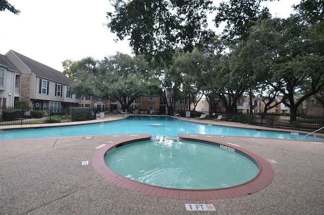 pool with a residential view and fence