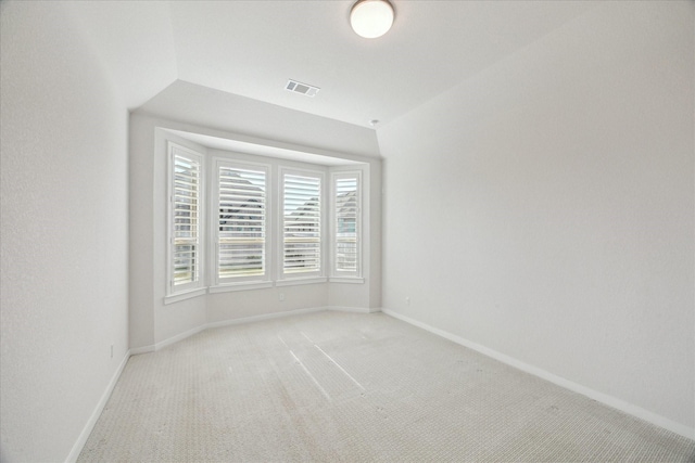 empty room with light colored carpet, visible vents, and baseboards