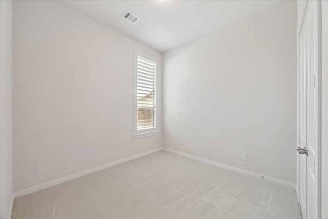 unfurnished room featuring visible vents, light carpet, and baseboards