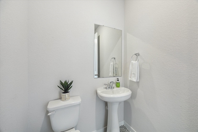 bathroom with baseboards and toilet