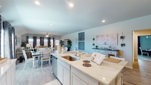 kitchen with wood finish floors, a sink, white cabinets, dishwasher, and ceiling fan