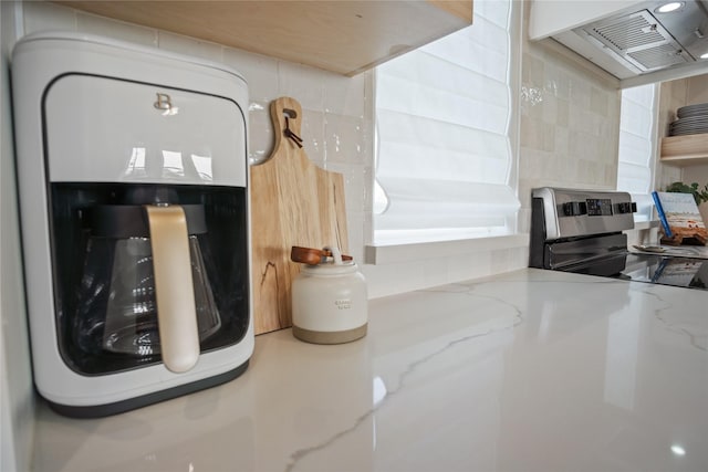 interior details with ventilation hood, light stone counters, and stainless steel range with electric cooktop