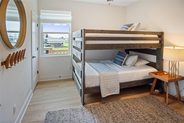 bedroom featuring baseboards and light wood finished floors