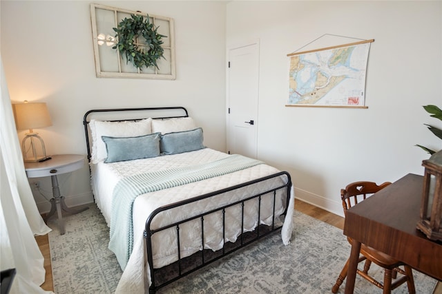 bedroom with baseboards and wood finished floors