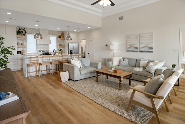 living room with recessed lighting, visible vents, light wood-style flooring, and a ceiling fan