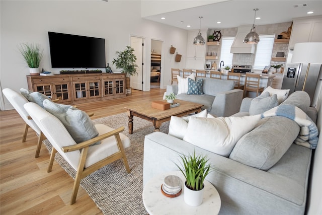 living room with visible vents, recessed lighting, and light wood-type flooring