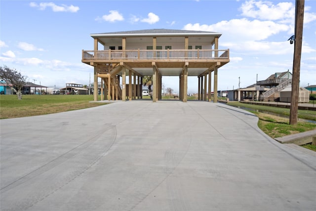 coastal inspired home featuring stairway, a carport, and concrete driveway