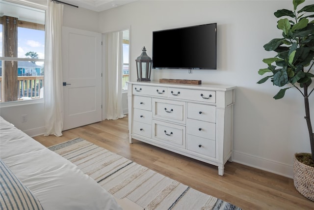 bedroom featuring light wood-style flooring, baseboards, and multiple windows