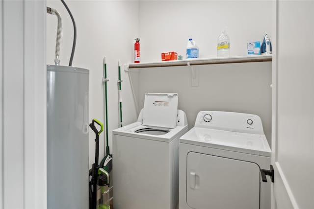 washroom featuring laundry area, water heater, and washing machine and clothes dryer