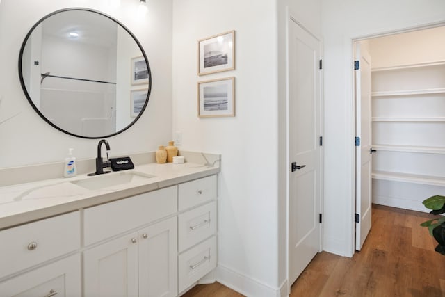 bathroom with vanity, baseboards, and wood finished floors