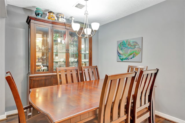 dining room with visible vents, baseboards, an inviting chandelier, and wood finished floors