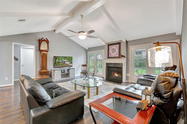 living area featuring lofted ceiling with beams, plenty of natural light, wood finished floors, and visible vents