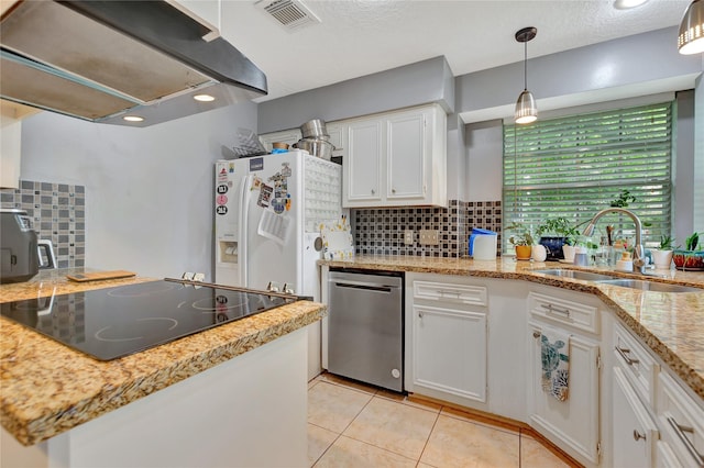 kitchen featuring visible vents, a sink, cooktop, extractor fan, and white fridge with ice dispenser