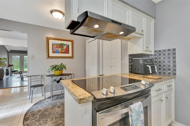 kitchen featuring range hood, light tile patterned floors, electric range, white cabinets, and tasteful backsplash