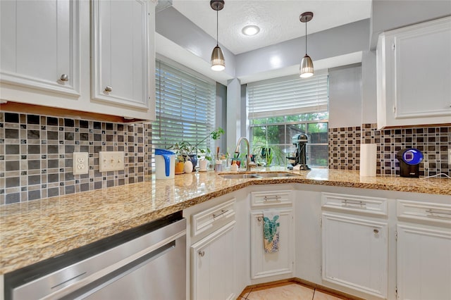 kitchen featuring decorative light fixtures, dishwasher, white cabinets, a textured ceiling, and a sink