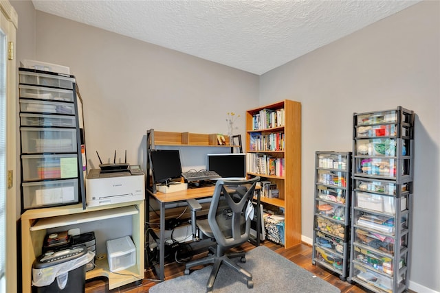 office with a textured ceiling, baseboards, and wood finished floors