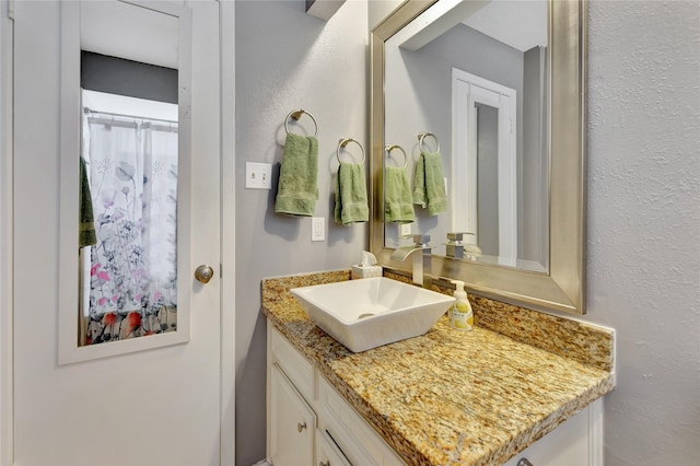 bathroom with vanity and a textured wall