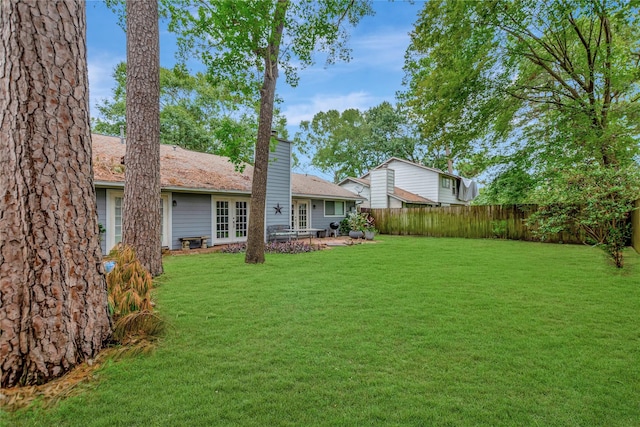 view of yard with french doors and fence