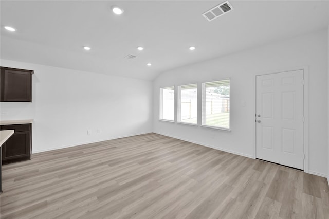 unfurnished living room with visible vents, recessed lighting, baseboards, light wood-style floors, and lofted ceiling