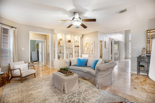 living area with visible vents, baseboards, and a ceiling fan