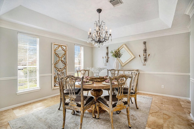 dining area with visible vents, a notable chandelier, ornamental molding, a tray ceiling, and baseboards