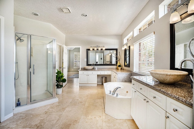 full bathroom featuring a shower stall, a garden tub, and a sink