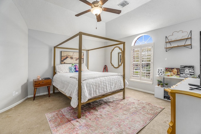 carpeted bedroom featuring lofted ceiling, baseboards, visible vents, and a textured ceiling