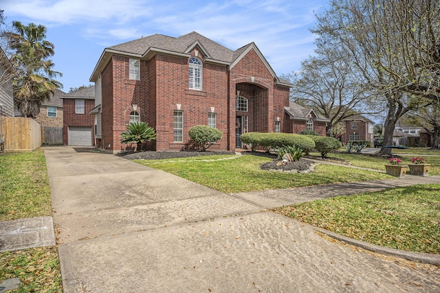 traditional home featuring driveway, fence, a front yard, a garage, and brick siding