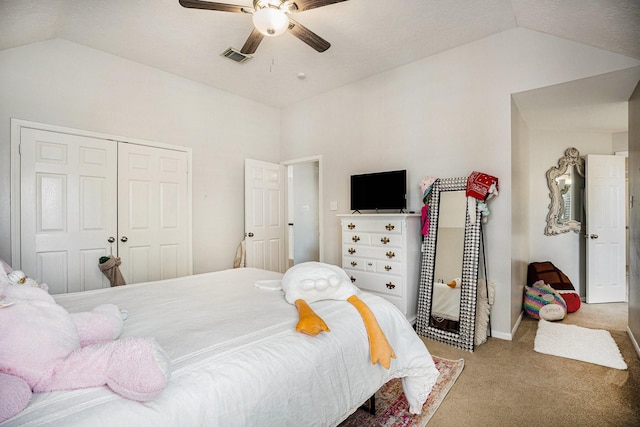 bedroom with visible vents, vaulted ceiling, carpet flooring, a closet, and a ceiling fan