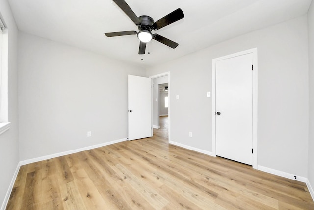 unfurnished bedroom featuring baseboards, light wood-style floors, and ceiling fan