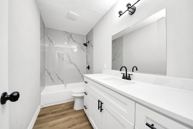 full bath featuring toilet, vanity, wood finished floors, a textured ceiling, and  shower combination