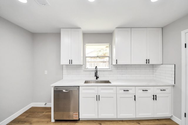 kitchen with baseboards, visible vents, a sink, light countertops, and stainless steel dishwasher