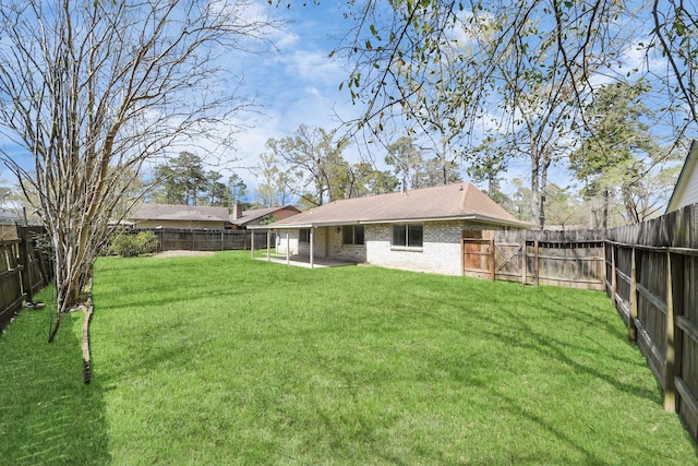 back of property featuring a patio, a yard, a fenced backyard, and brick siding