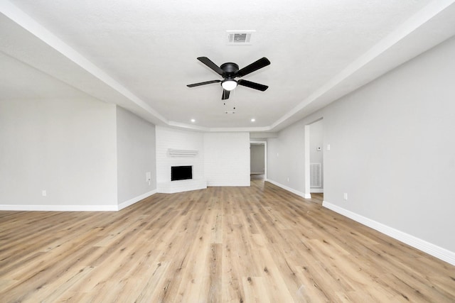 unfurnished living room featuring visible vents, baseboards, light wood-style floors, and a ceiling fan