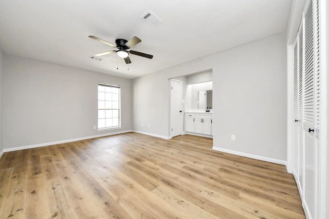 unfurnished bedroom with visible vents, baseboards, light wood-style floors, and ensuite bath