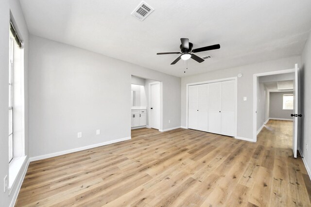 unfurnished bedroom with light wood-type flooring, visible vents, baseboards, and a closet