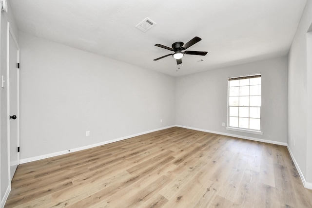 unfurnished room with visible vents, baseboards, wood finished floors, and a ceiling fan