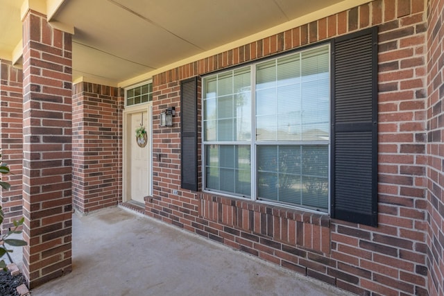 property entrance with brick siding and covered porch