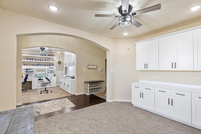 kitchen with a ceiling fan, recessed lighting, arched walkways, white cabinetry, and light wood-type flooring