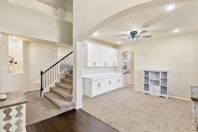 interior space with baseboards, dark wood-style floors, recessed lighting, arched walkways, and a ceiling fan