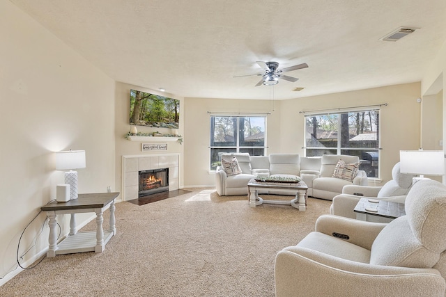 living room with visible vents, carpet floors, a fireplace, baseboards, and ceiling fan