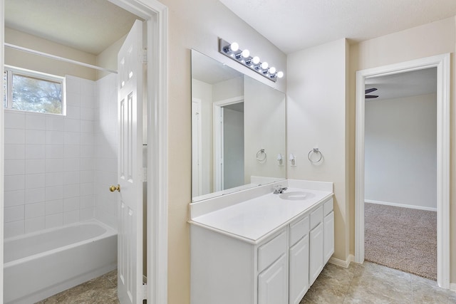 bathroom featuring baseboards, shower / bathtub combination, and vanity