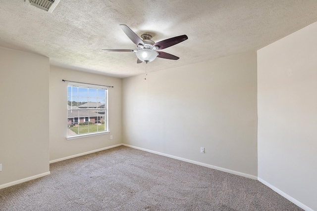 carpeted spare room featuring visible vents, a textured ceiling, baseboards, and a ceiling fan